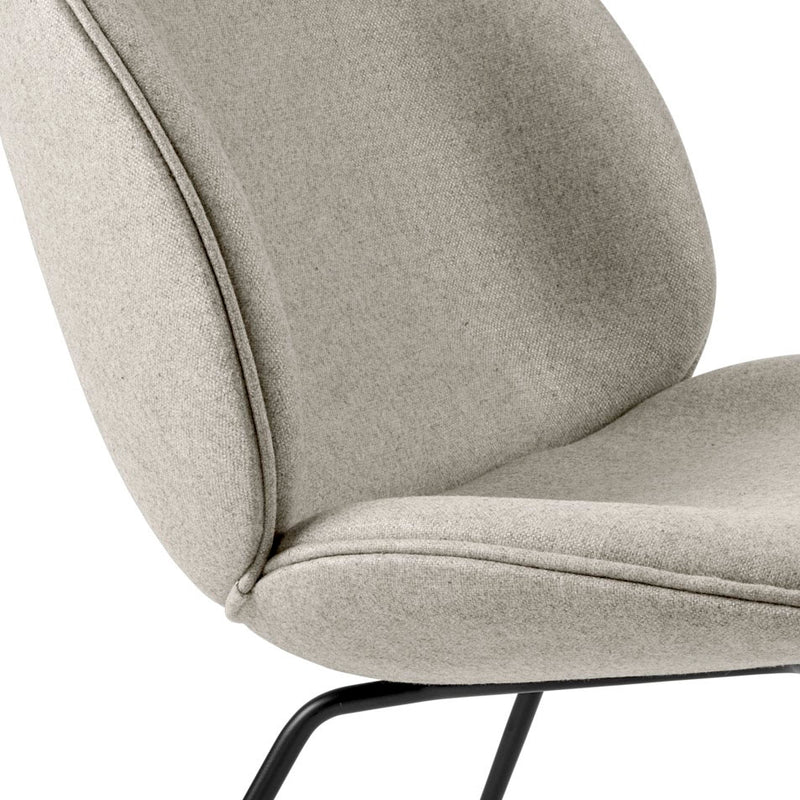 Close-up of light gray textured fabric chair seat and curved backrest with slender black metal legs
