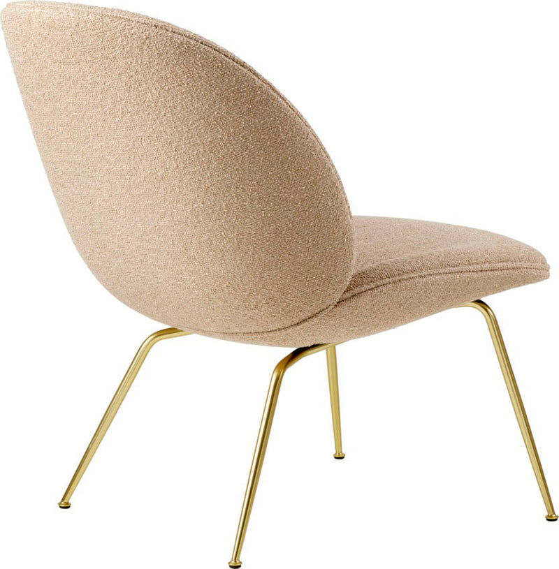 Lounge chair with rounded beige boucle upholstery and slender polished gold metal legs angled outward