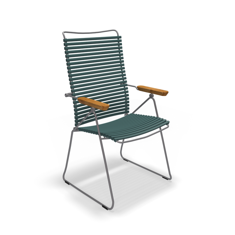 The Click Position Chair by Houe features a modern design with weather-resistant dark green slatted plastic lamellas, wooden armrests, and a thin metal frame with angled legs, making it perfect for any patio setting.
