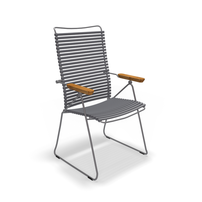 The Click Position Chair by Houe is a modern outdoor chair with a metal frame and weather-resistant design, featuring wooden armrests, plastic lamellas, a slightly reclined backrest, and a minimalist pipe-style base—ideal for any open-air setting.