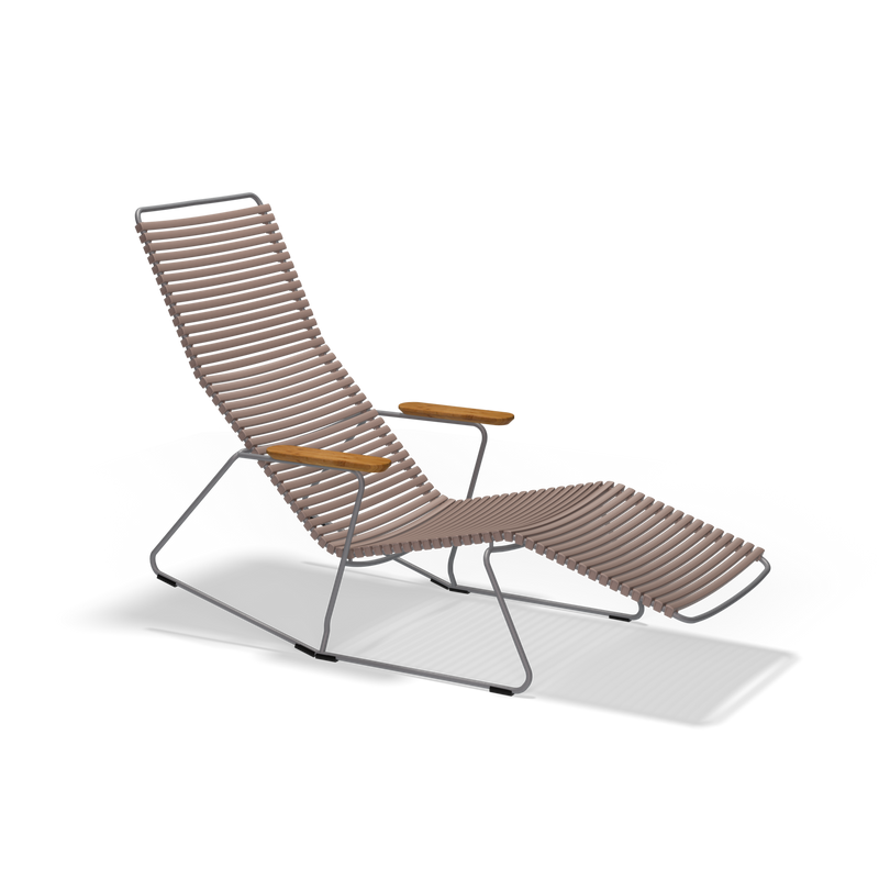 The Click Sunrocker by Houe is a modern reclining chair featuring brown woven straps on a black metal frame, wooden armrests, and angled legs. Perfect for outdoor lounging, it complements stylish outdoor chairs.