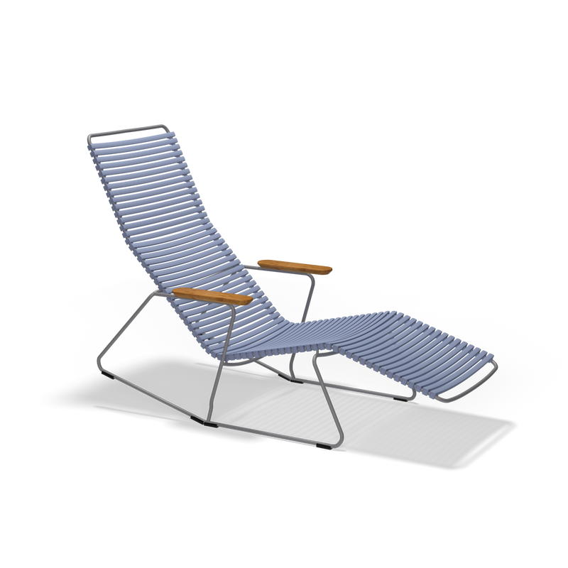 The Click Sunrocker by Houe is a sleek, minimalist lounge chair made of powder-coated black metal. It features parallel blue plastic lamellas on the seat and backrest, with wooden armrests that add stylish contrast, ideal for outdoor use.