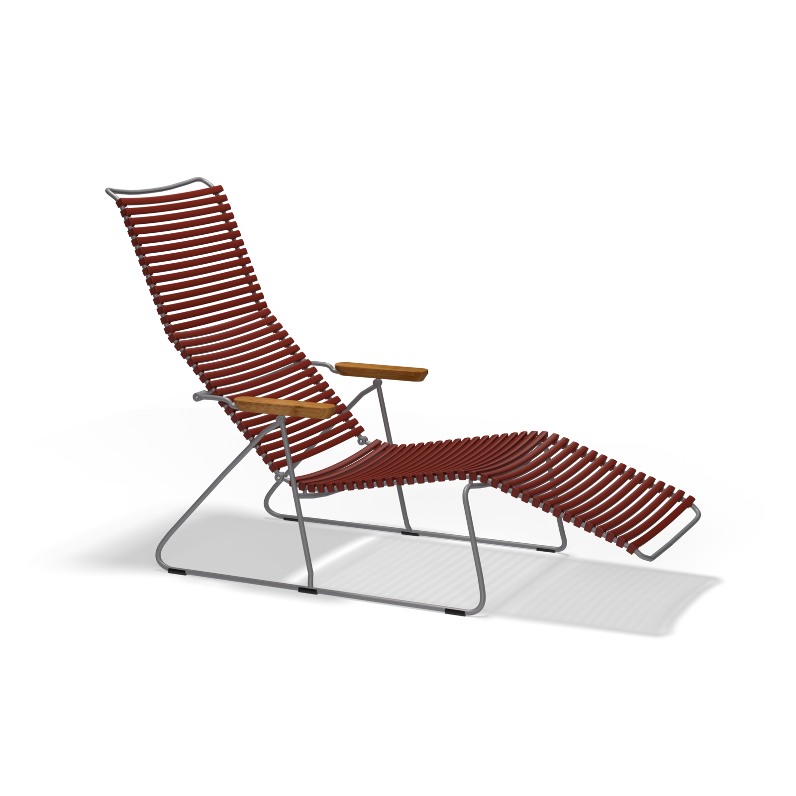 The Click Sunlounger by Houe features a sleek metal frame with UV-protected, curved design. It has red ribbed cushioning and wooden armrests for stylish comfort, set against a solid black background.