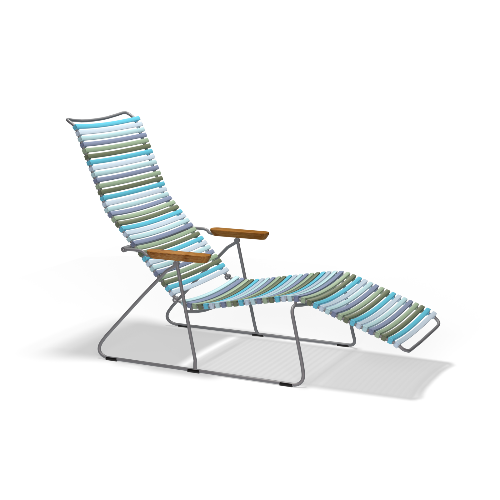 The Click Sunlounger by Houe is a colorful lounge chair with a metal frame and wooden armrests, designed for UV-protected outdoor use. It features cushion-free seating with an extended leg rest and high backrest in blue, green, and beige stripes on a black background.