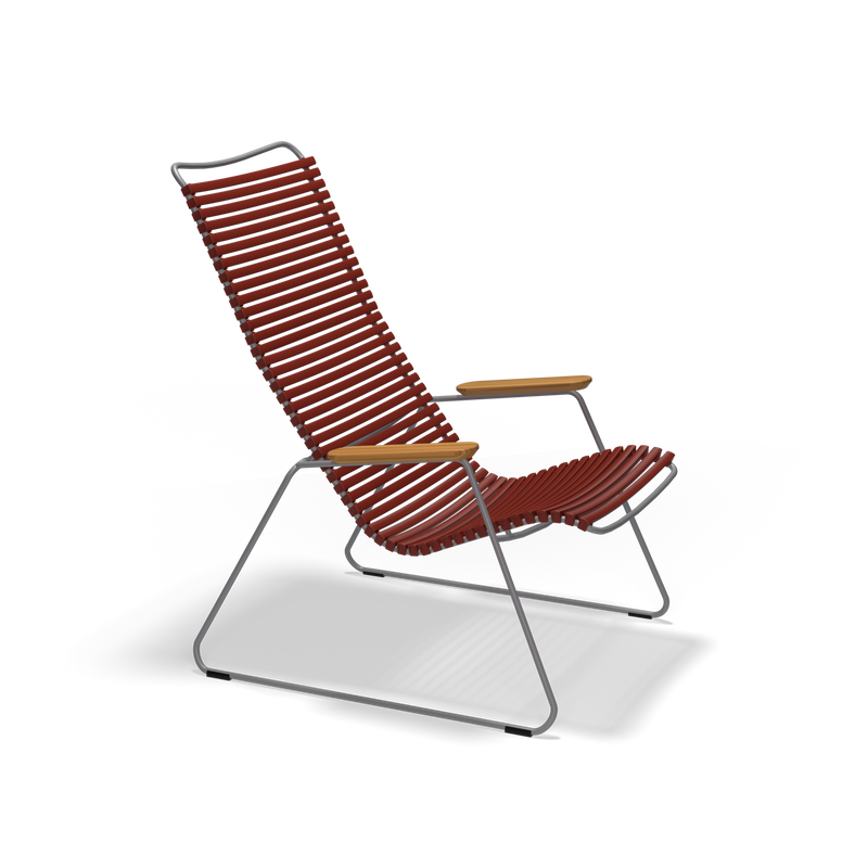 The Click Lounge Chair by Houe features a modern design with high backrest, red plastic lamellas, a sleek gray metal frame, and wooden armrests. Its minimalist and angular style is perfect for outdoor settings against a plain black background.