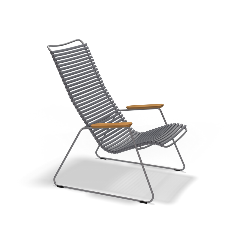 The Click Lounge Chair by Houe is a sleek, minimalist chair featuring a weather-resistant metal frame and slatted back and seat. Its bamboo armrests contrast beautifully with the dark frame, making it ideal for outdoor use against a plain black background.