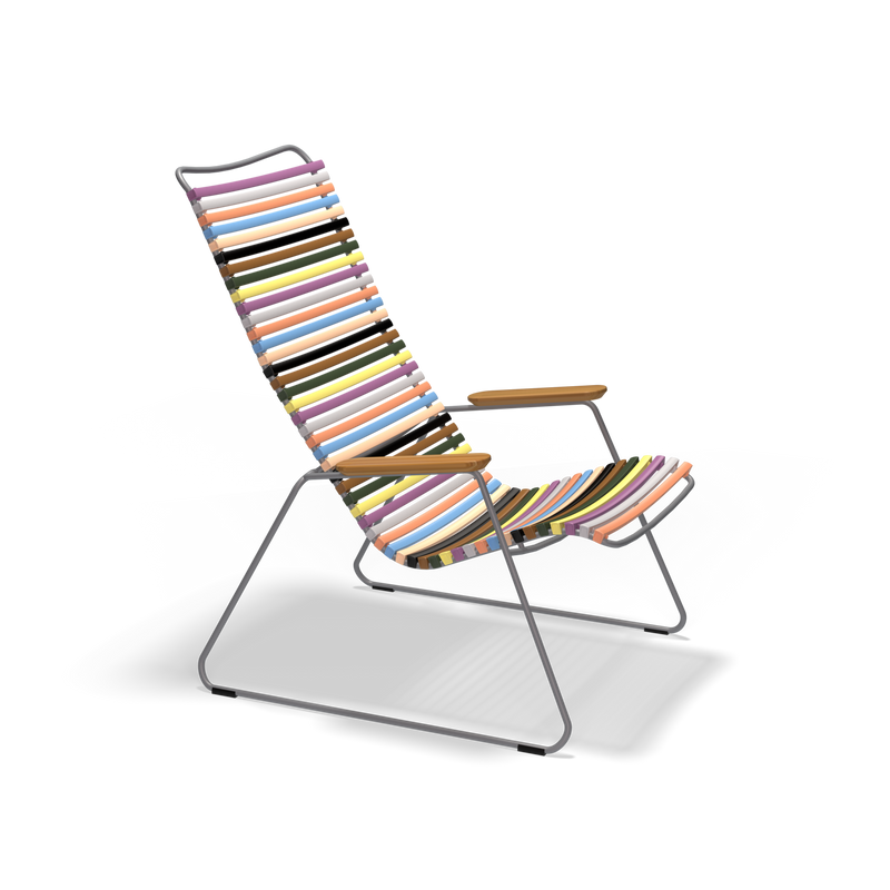 The Houe Click Lounge Chair is ideal for outdoor relaxation with its colorful striped design, featuring a durable metal frame, wooden armrests, and vibrant plastic lamellas that stand out against a black background.