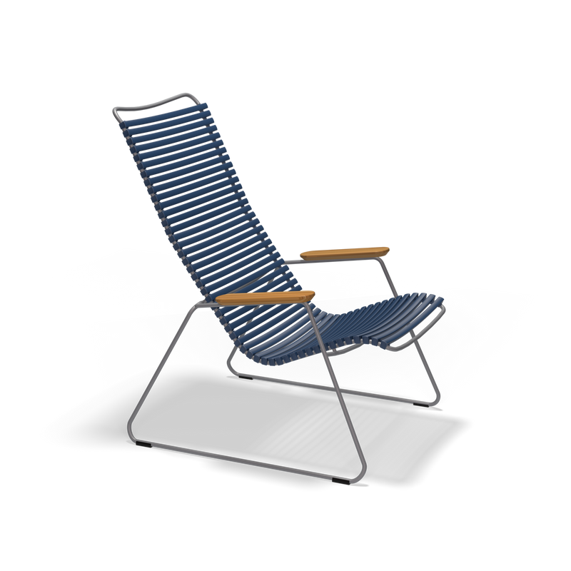 The Click Lounge Chair by Houe is a stylish outdoor seating option, featuring a weather-resistant metal frame, blue slatted seat and backrest, light wooden armrests, and a minimalist design. Set against a black background, its the perfect modern addition to any patio.