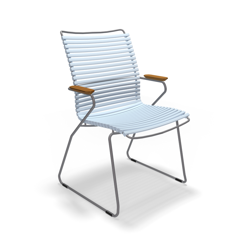 The Houe Click Dining Chair with Armrest features a tall, modern white slatted seat and back, thin metal armrests with wooden accents, and sleek metal legs set against a black background. This minimalist and contemporary design is weather-resistant, ideal for various outdoor conditions.