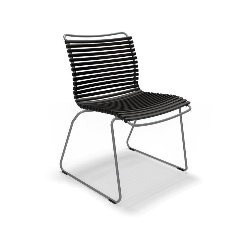 The Click Dining Chair without Armrest by Houe features weather-resistant black plastic lamellas on the seat and backrest, supported by a sleek metal frame with curved legs. Its industrial, minimalist design is striking against a black backdrop.