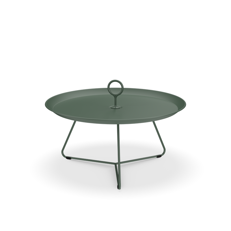 The Eyelet Tray Table by Houe is a sleek, minimalist side table made from powder-coated steel in dark green. It has a raised edge, central handle, and three slightly outward-tapering slender legs for modern elegance against a solid black background.