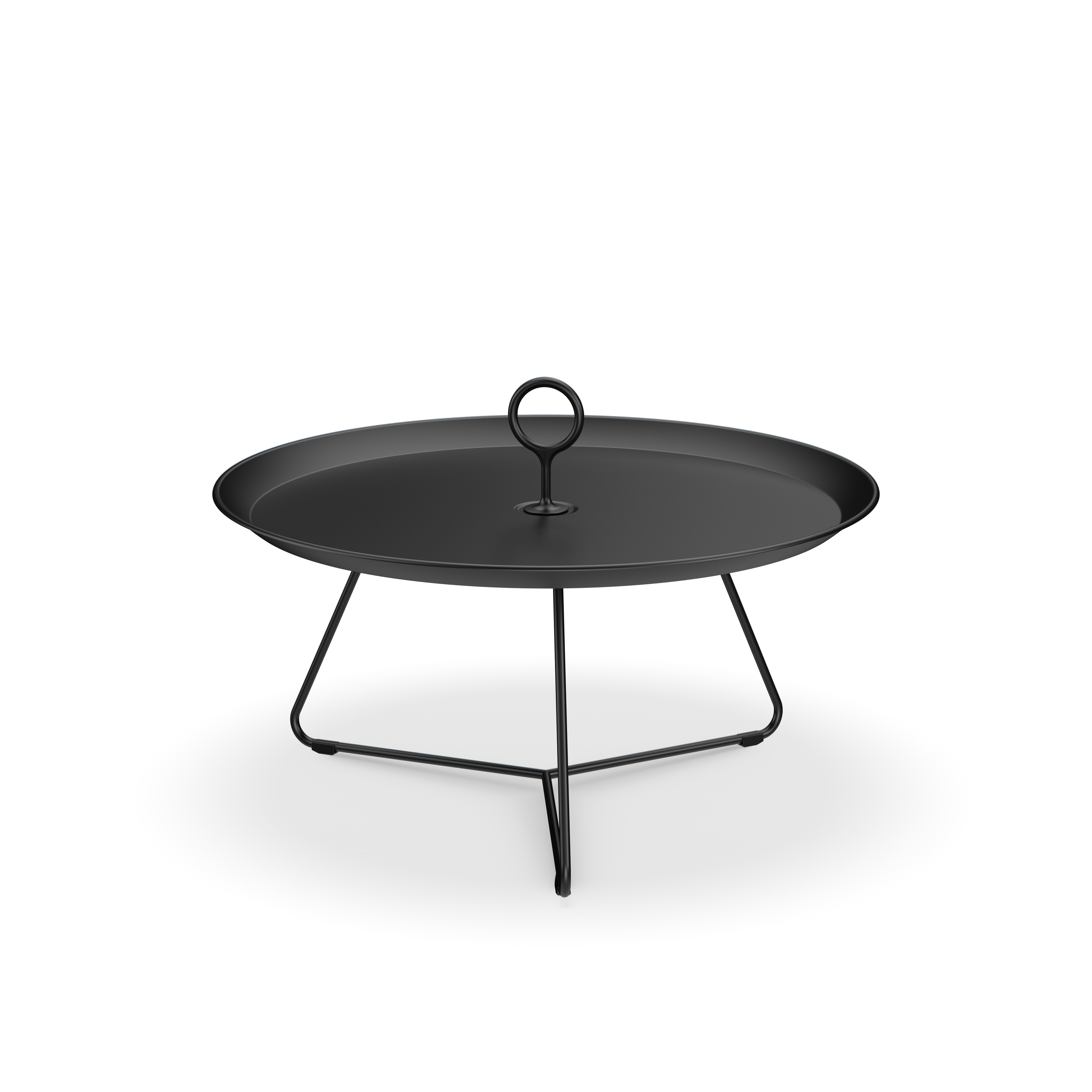 The Houe Eyelet Tray Table, a round black powder-coated steel tray with a raised rim and central handle, sits elegantly on a tripod stand against the black background, showcasing stylish minimalism.