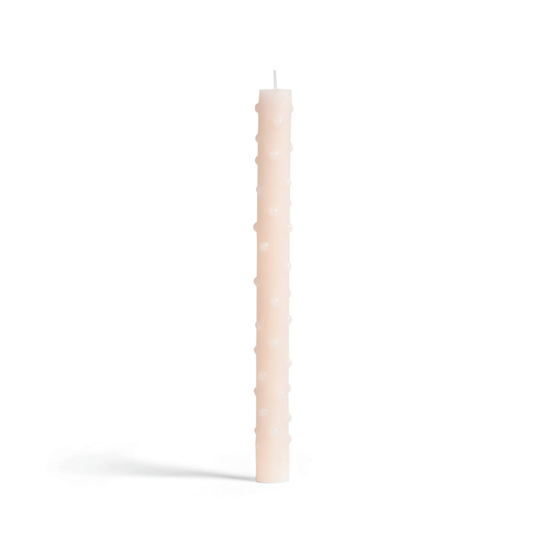 A tall, slender beige candle by &Klevering features a textured surface with spherical bumps, standing upright against a plain white background. This candle complements any decor with its elegant and unique design.