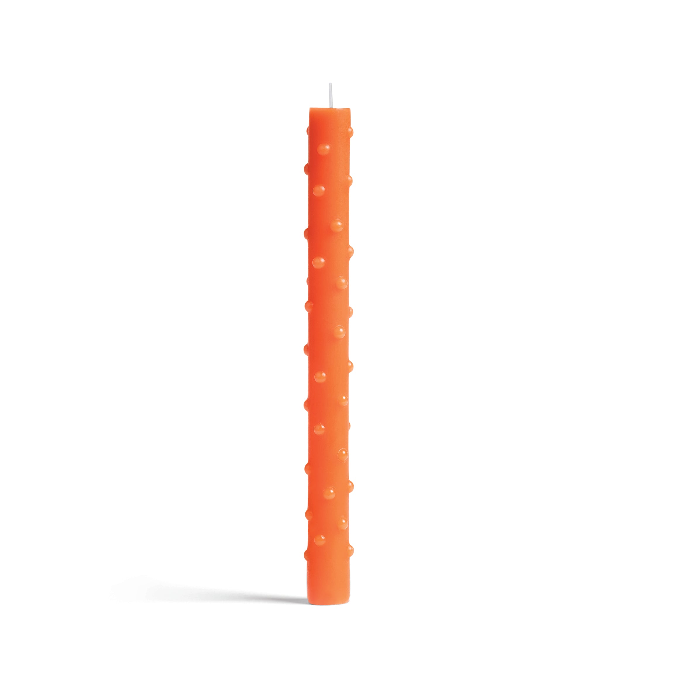 The &Klevering Candles feature an orange, textured design with raised vertical circles, elegantly contrasting against a plain white background.