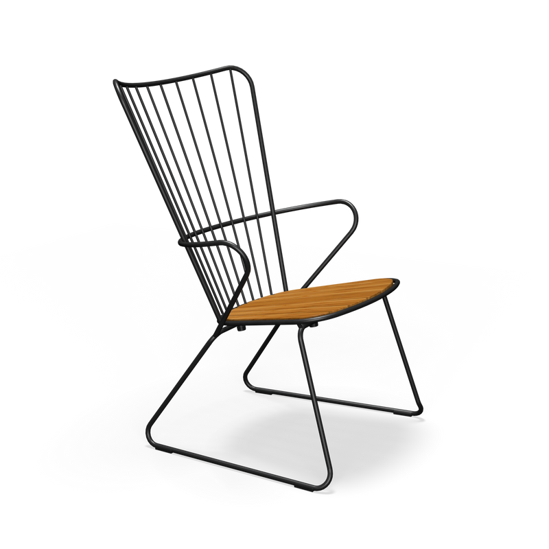 The Paon Lounge Chair by Houe features a sleek black powder-coated steel frame and a wooden slatted seat. Its angled backrest with vertical metal bars and angular legs creates a minimalist design, combining style and comfort effortlessly.