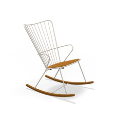 The Houe Paon Rocking Chair features a sleek white powder-coated steel frame with wooden seat and rockers. Its minimalist design includes vertical slats forming the backrest, creating a contemporary yet classic look against a black backdrop.