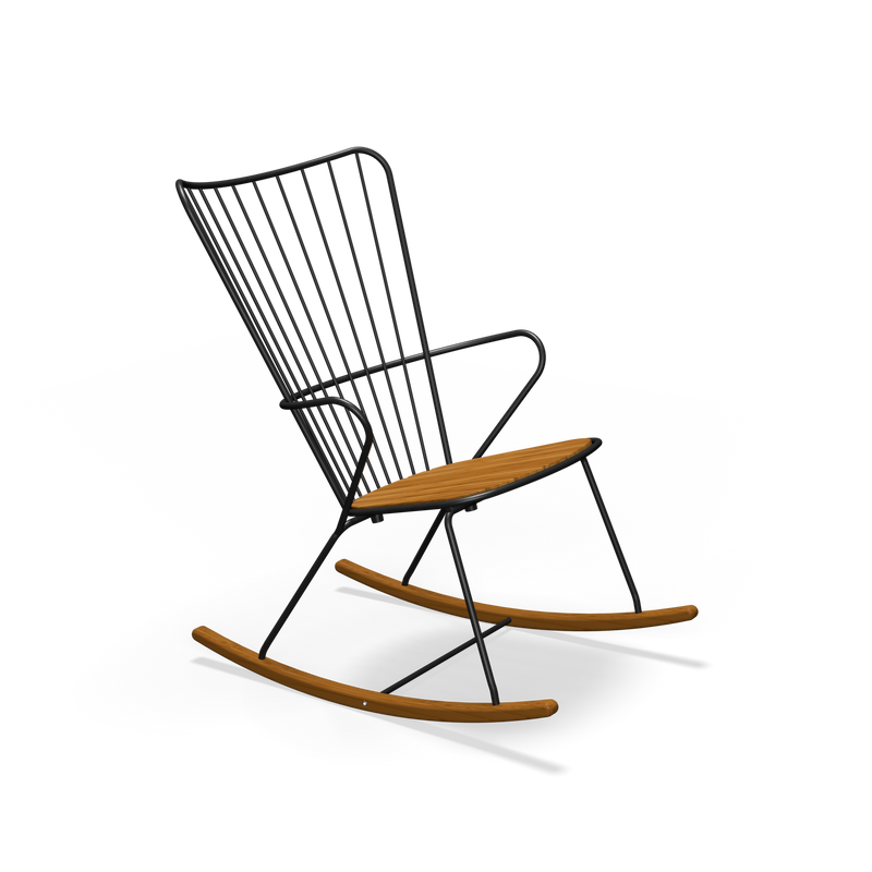 A sleek, modern Paon Rocking Chair by Houe features a black powder-coated steel frame, wooden seat and rockers, and a minimalist design with vertical metal bars in the backrest, set against a plain black backdrop.