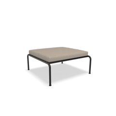The Avon Ottoman by Houe features a minimalist design with a beige cushioned seat and slender black metal legs, showcased against a plain white background. Perfect addition to any lounge collection.