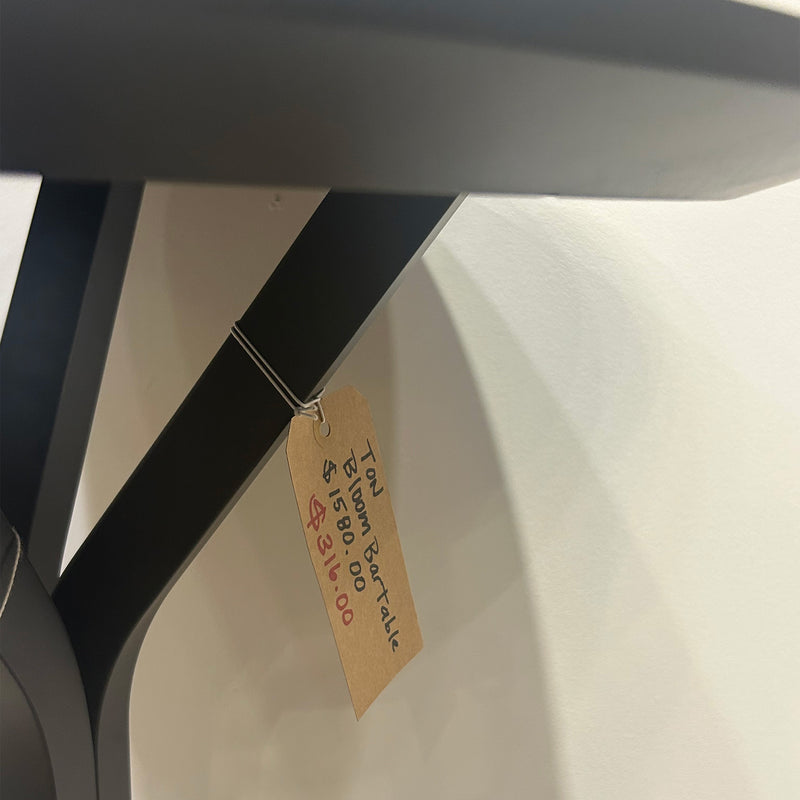 Bloom Bar Table Round - Sale showing black metal frame and price tag hanging on leg of table.