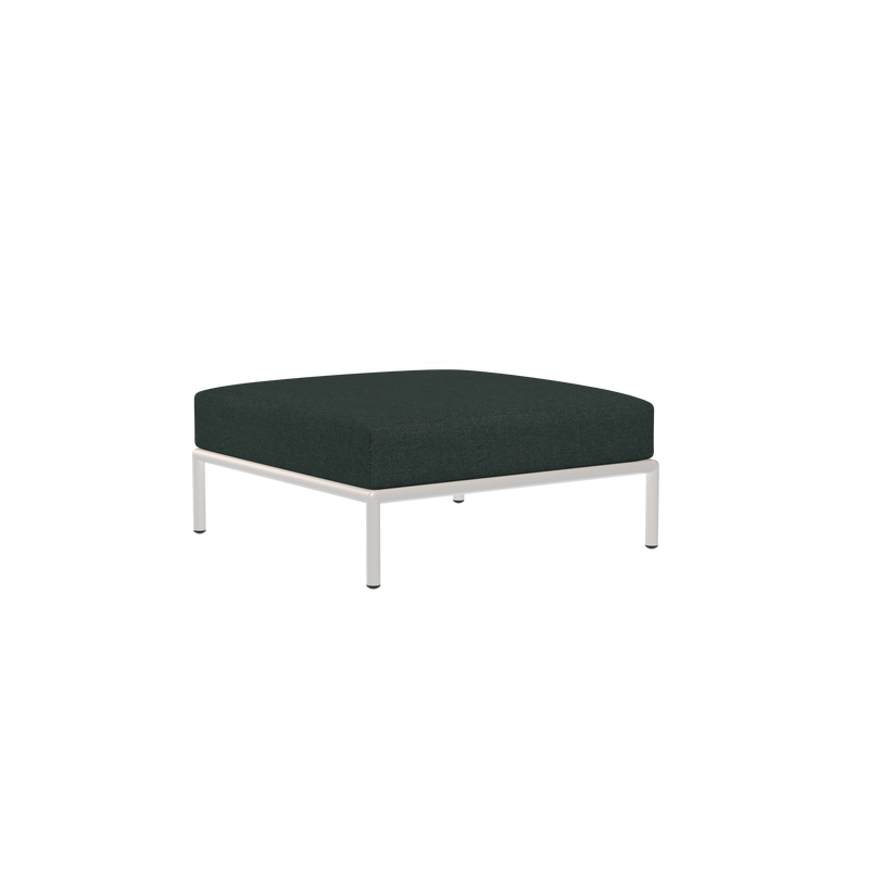 The Houe Level Ottoman features a minimalist, square design with a black cushion made from water-repellent fabric and sleek metallic legs, set against a solid black background.
