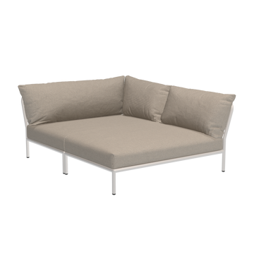 The Houe Level Cozy Corner is a beige L-shaped sectional sofa with a minimalist design, featuring plush cushions and a sturdy frame made from powder-coated aluminum against a sleek black backdrop.