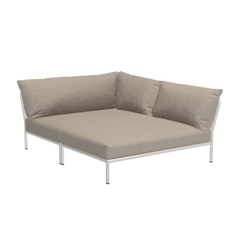 The Houe Level Cozy Corner is a beige L-shaped sectional sofa with a minimalist design, featuring plush cushions and a sturdy frame made from powder-coated aluminum against a sleek black backdrop.