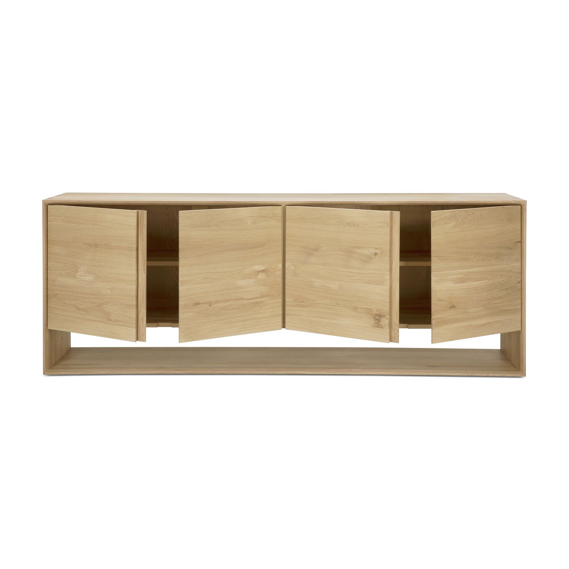 The Ethnicraft Nordic Sideboard features four cabinet doors, each slightly open to show an interior shelf. Its minimalist, rectangular form and natural wood finish are complemented by beveled edges, reflecting the signature Nordic collection style.