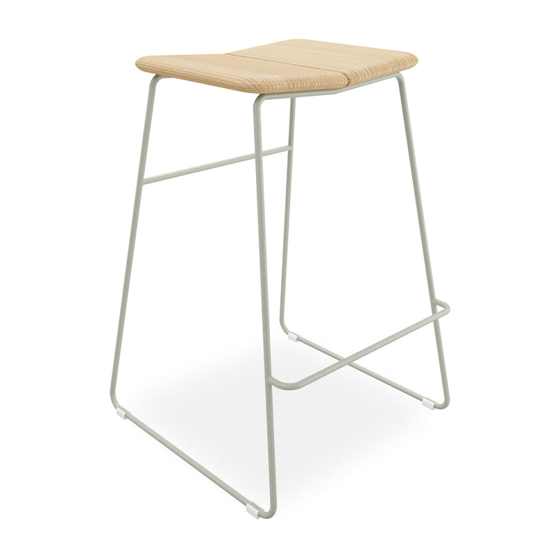 The Aero Bar Stool by Gus Modern features a light solid Ash wood seat, minimalist pale gray metal frame, footrest, and gently curved edges for a Scandinavian-inspired design.