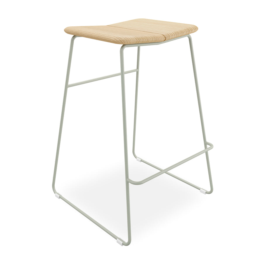 The Aero Bar Stool by Gus Modern features a light solid Ash wood seat, minimalist pale gray metal frame, footrest, and gently curved edges for a Scandinavian-inspired design.