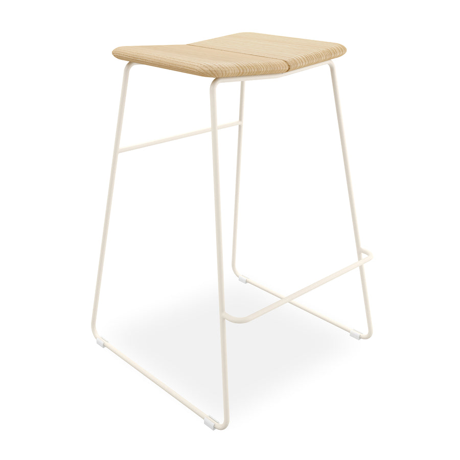 The Aero Bar Stool by Gus Modern showcases Scandinavian design with a curved solid Ash wood seat, slim white metal legs, a built-in footrest, and clean lines for a modern, minimalist look in neutral tones.