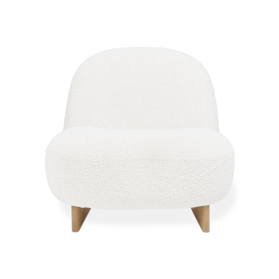 The Arlo Chair by Gus Modern showcases Scandinavian style with a rounded, armless lounge design, upholstered in white bouclé and supported by short, angled wooden legs.