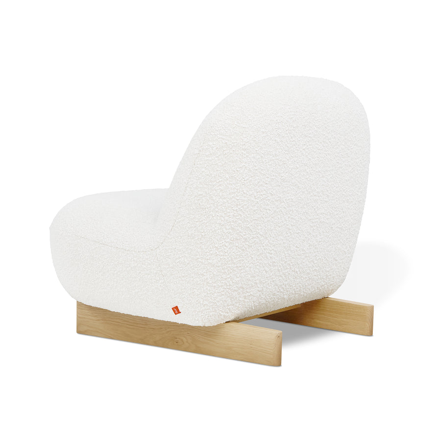 The Arlo Chair by Gus Modern features a modern white bouclé upholstered seat with a rounded back, supported by two simple light wooden legs, shown on a white background.