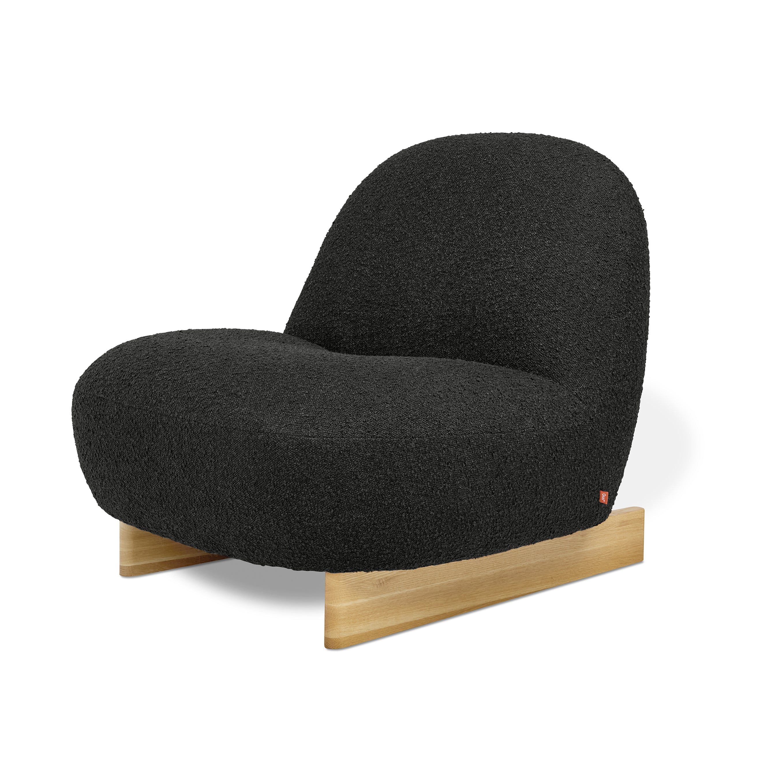 The Gus Modern Arlo Chair features Scandinavian-inspired design with a rounded plush black bouclé seat and backrest, set on a simple light wood base against a white background.