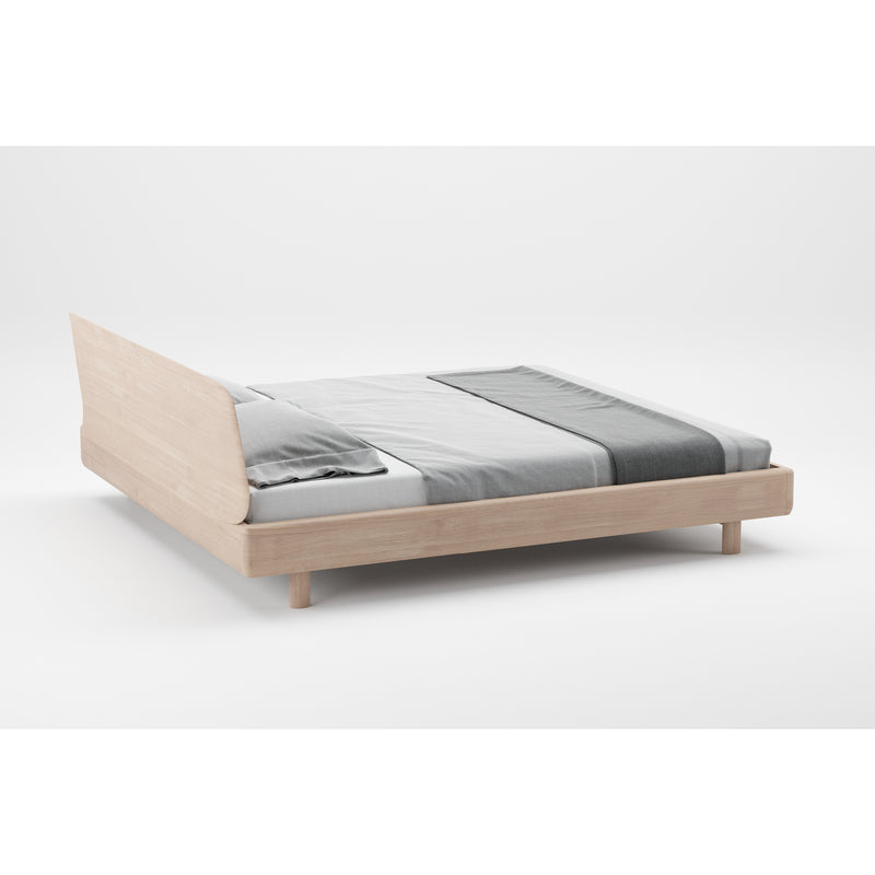 The FIN Bed by Artisan is a minimalist wooden bed crafted from solid wood, featuring a light frame and simple headboard. It includes gray and white bedding with a neatly folded duvet and pillows, showcasing clean lines and a modern aesthetic that beautifully highlights the natural wood texture.