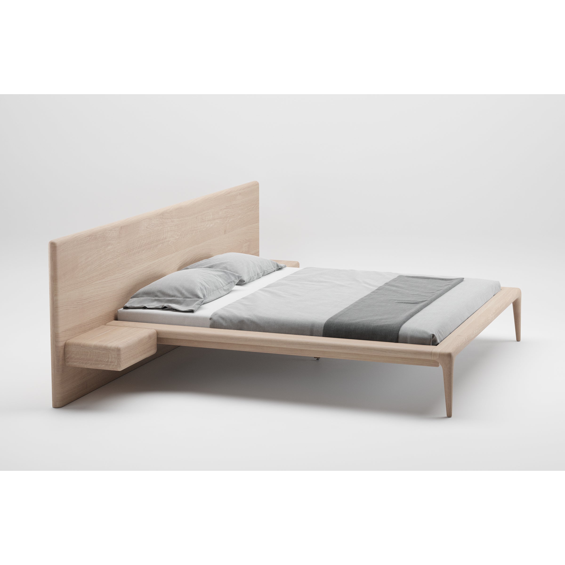 The LATUS Bed by Artisan is a minimalist wooden platform bed with a light wood finish, showcasing luxurious wood texture. It includes an extended headboard with an attached floating nightstand on the left and comes neatly made with gray and white bedding.