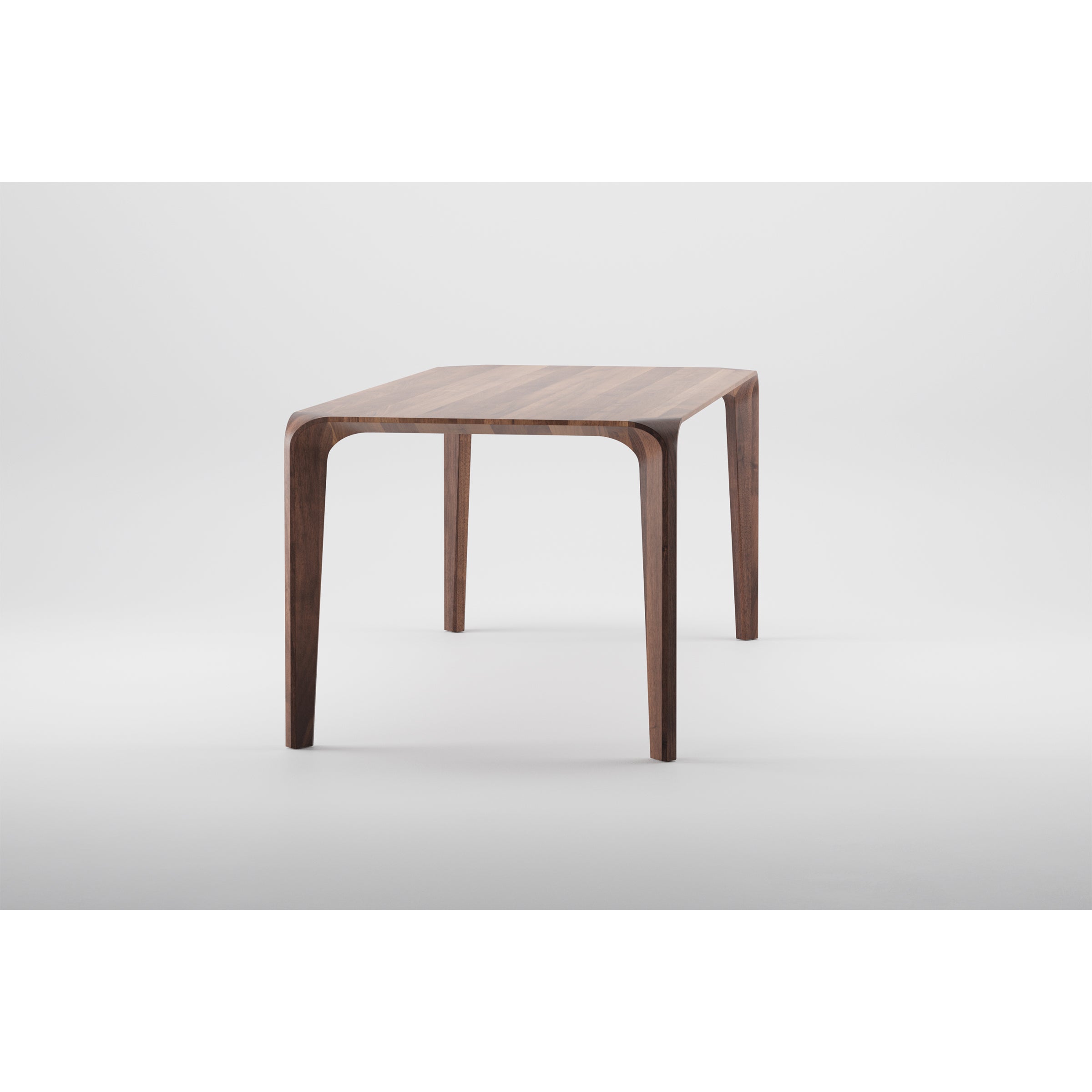 The FLOW Table by Artisan is a minimalist piece crafted from solid wood, featuring a rectangular top and slender curved legs. Set against a white background, its finished with natural oils for a smooth touch and an eco-friendly, modern design.