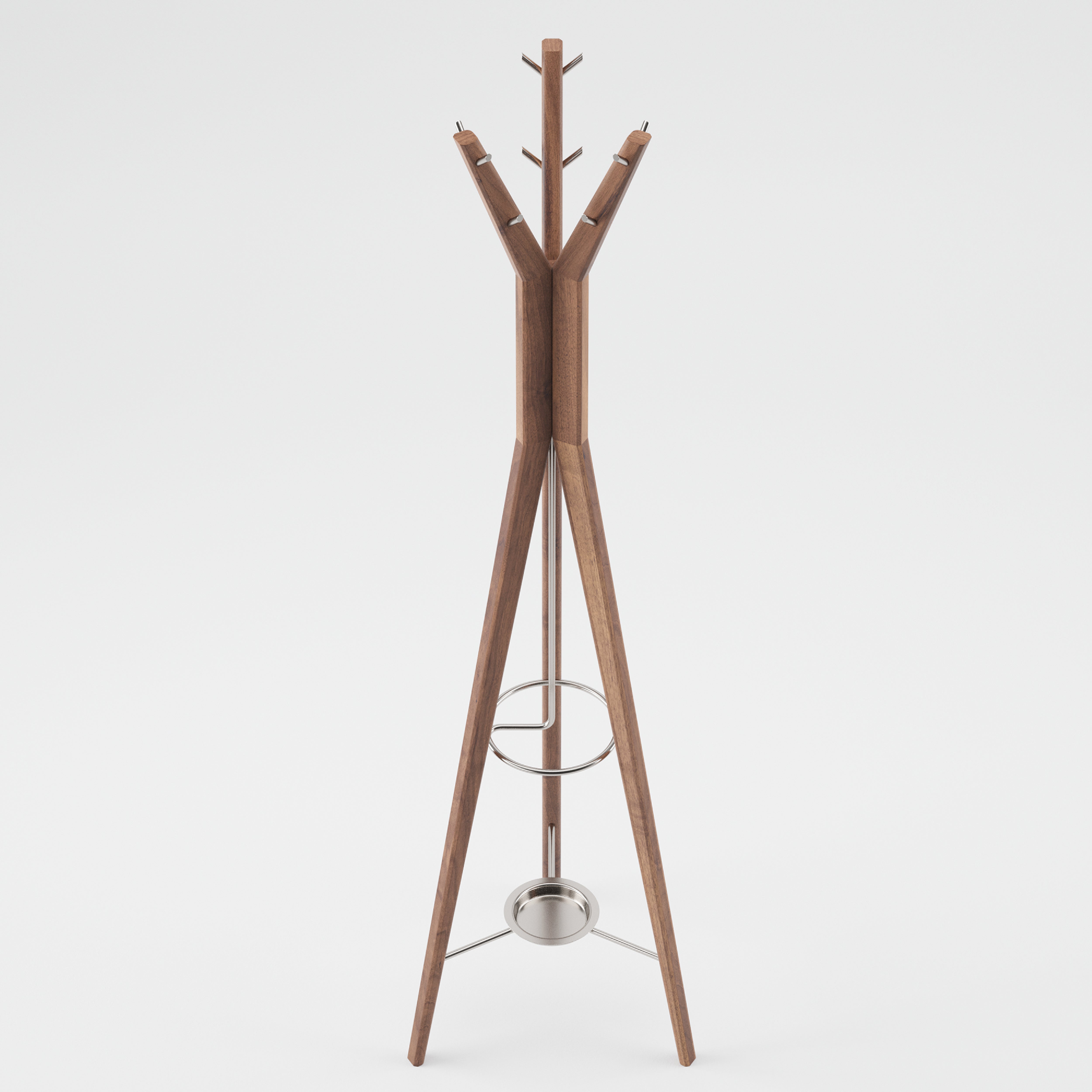 The HANNY Coat Stand by Artisan boasts a minimalist design crafted from eco-friendly solid wood. It features three tall legs, circular hooks on top, a small metal ring for extra hanging space, and a round metal tray near the base, all set against a plain white background.