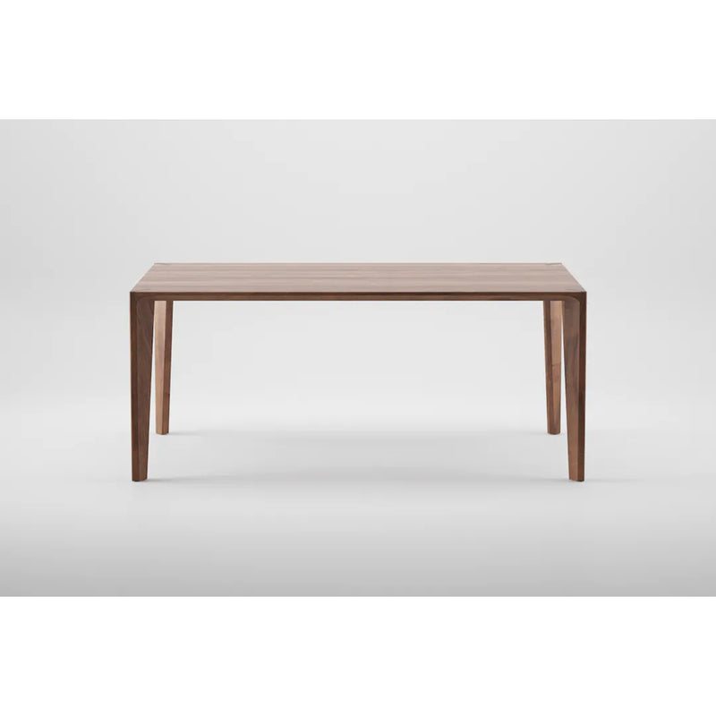 The Artisan HANNY Extension Table features a minimalist design with a rectangular top and four tapered legs. Crafted from eco-friendly materials, its clean lines and natural wood finish are accentuated against a plain white background.