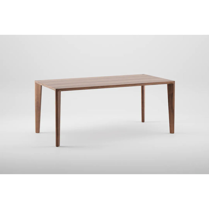 The Artisan HANNY Extension Table features a wooden rectangular design with a minimalist style and four tapered legs, crafted from eco-friendly materials, set against a plain white background.