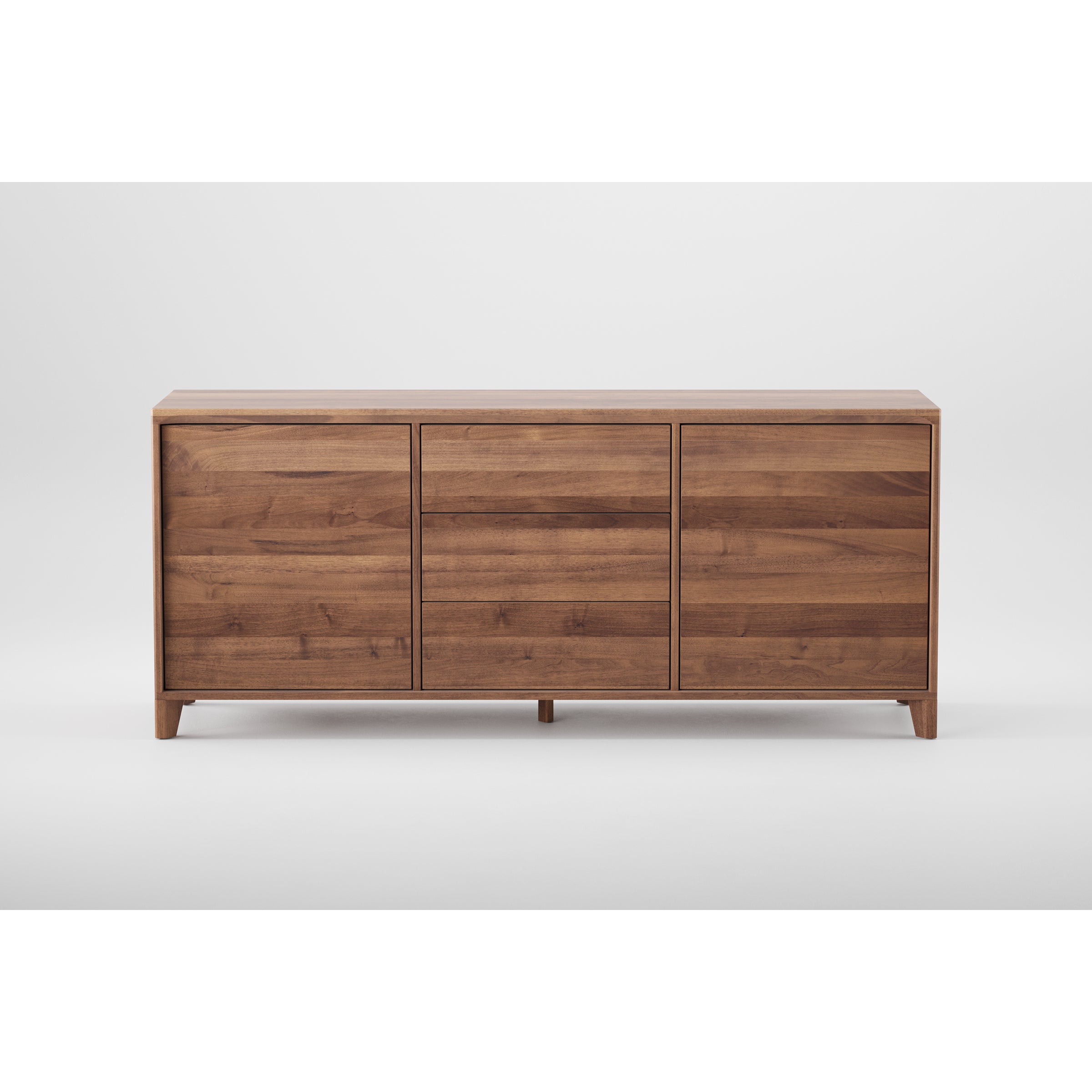 The HANNY Sideboard by Artisan features a minimalist design made from solid wood, finished with natural oils and wax. It includes three drawers, short legs, and a smooth light brown finish that contrasts beautifully against a plain white background.