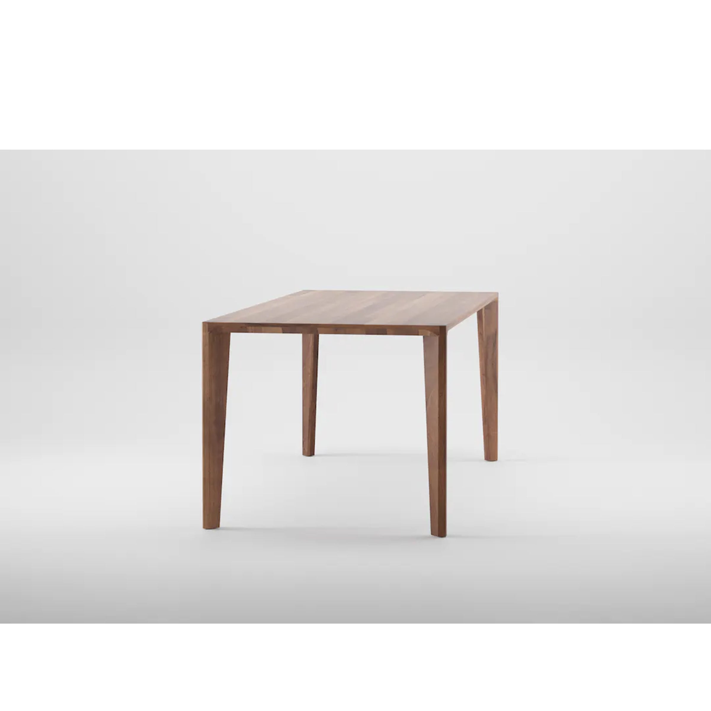 The Artisan HANNY Table presents a minimalist design with a solid wood rectangular top and four tapered legs, finished in natural oils and wax, styled against a plain white backdrop.