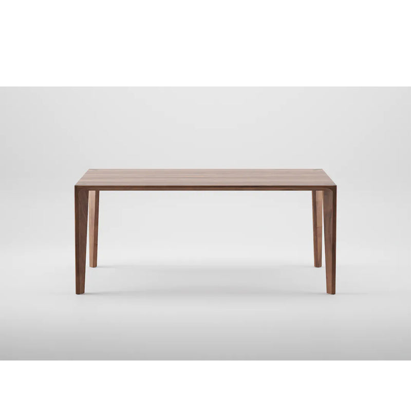The HANNY Table by Artisan features a rectangular solid wood top with four sturdy legs on a plain white background. Its minimalist design highlights the natural wood grain, crafted using eco-friendly materials.