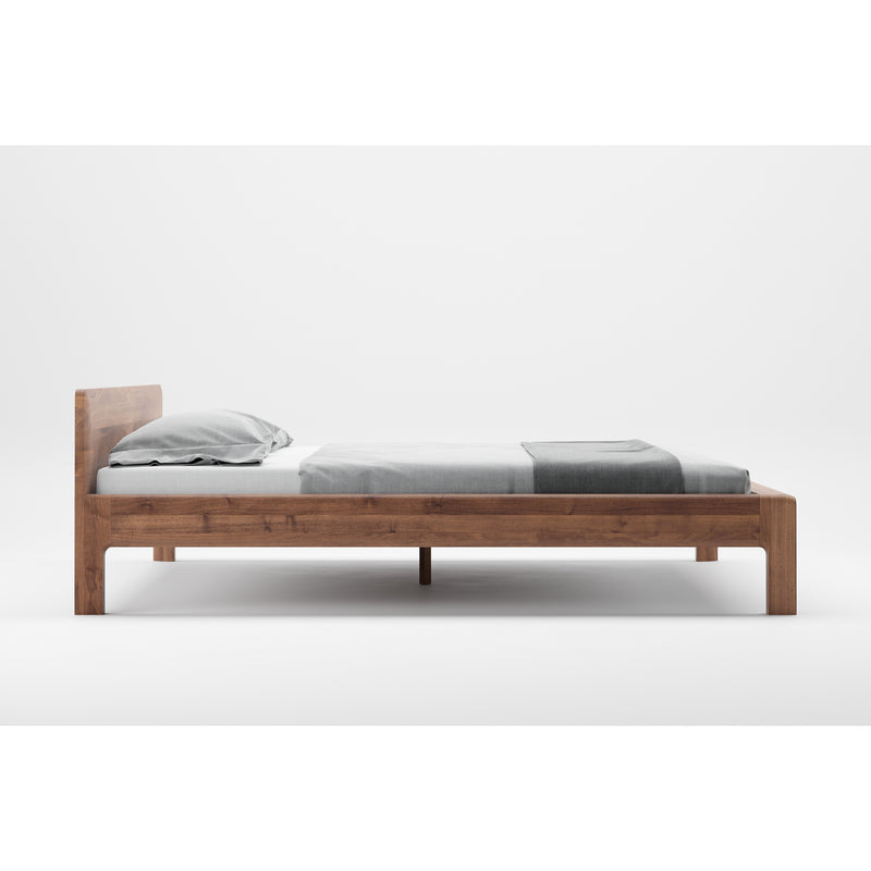 The Artisan INVITO Bed features a minimalist wooden design on a white background, crafted from eco-friendly materials with a natural wood texture. Its light-colored finish complements the white sheet, gray blanket, and pillow, enhancing its simple and modern look.
