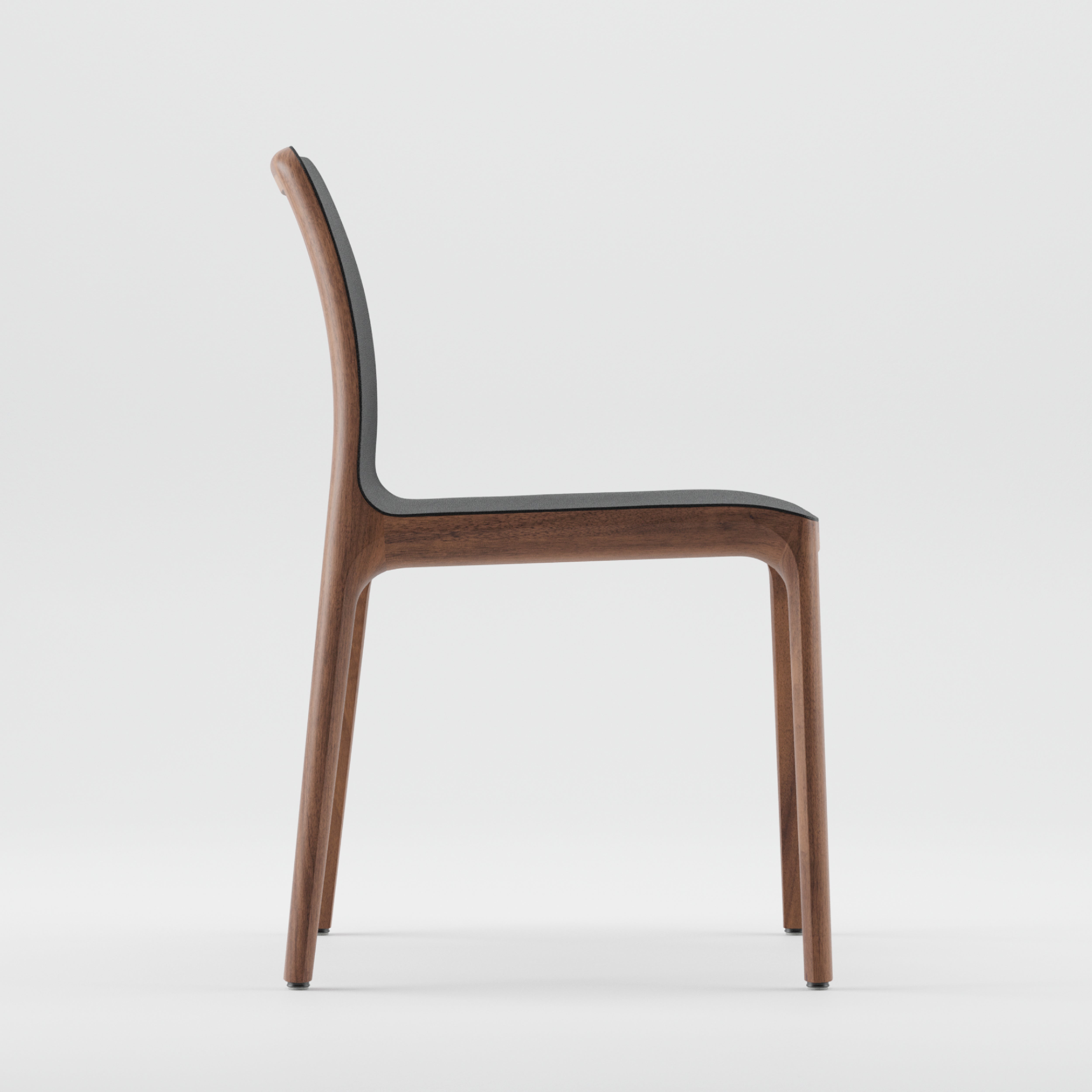 Side view of the modern, minimalist INVITO Chair by Artisan, crafted from solid wood with a dark, smooth seat and backrest. Its sleek design is highlighted against a plain white background, showcasing its eco-friendly materials.