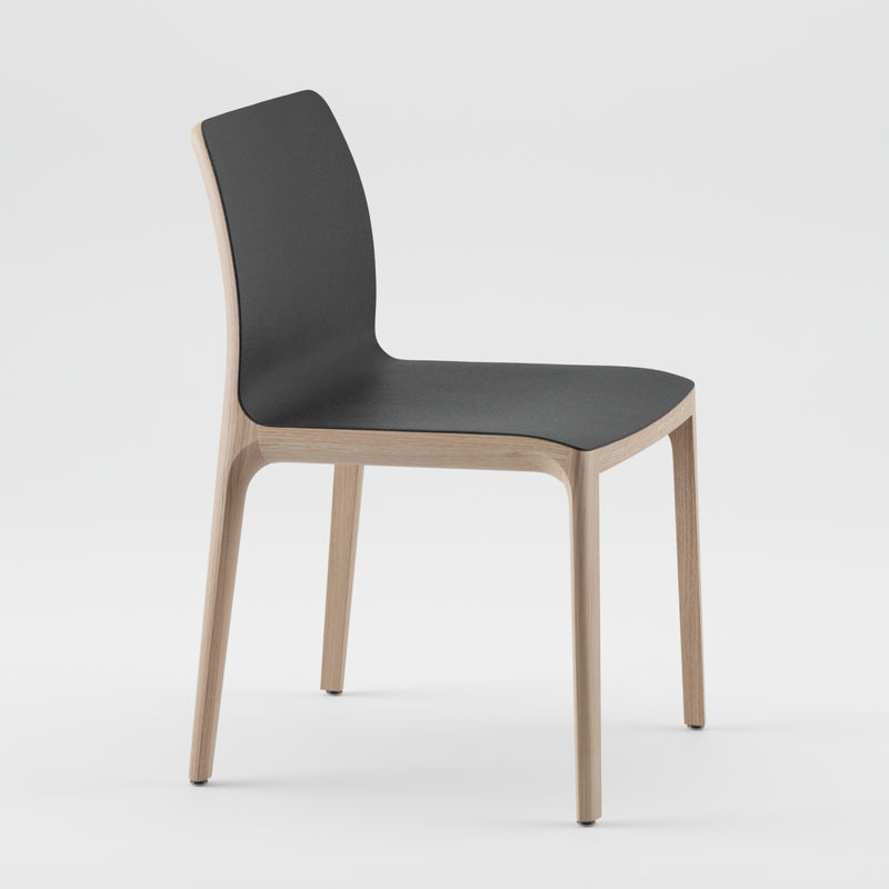 The INVITO Chair by Artisan features a sleek black seat and backrest paired with light solid wood legs and frame. Crafted from eco-friendly materials, its minimalist design stands out elegantly against a plain white background.