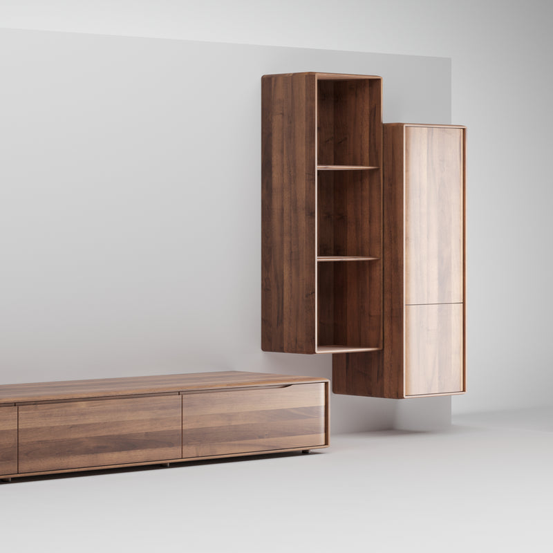The INVITO MS Wall Modules by Artisan create a minimalist living room with a wall-mounted wooden cabinet featuring open shelves and a closed compartment beside a low console table. Crafted from eco-friendly materials, the sleek design showcases a natural wood finish against light gray walls.