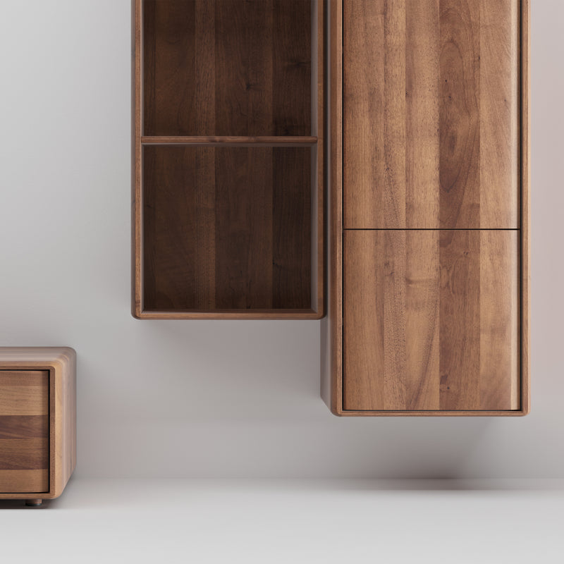Artisans INVITO MS Wall Modules feature minimalist solid wood cabinets mounted on a light wall. The design includes a sleek, modern aesthetic with the larger module sporting two doors and the smaller one showcasing open shelving, highlighted by an elegant wood grain.