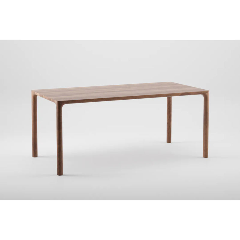 The JEAN Table by Artisan is a minimalist, rectangular solid wood piece with a smooth finish and four slightly curved legs, exhibiting exquisite craftsmanship against a plain white background.