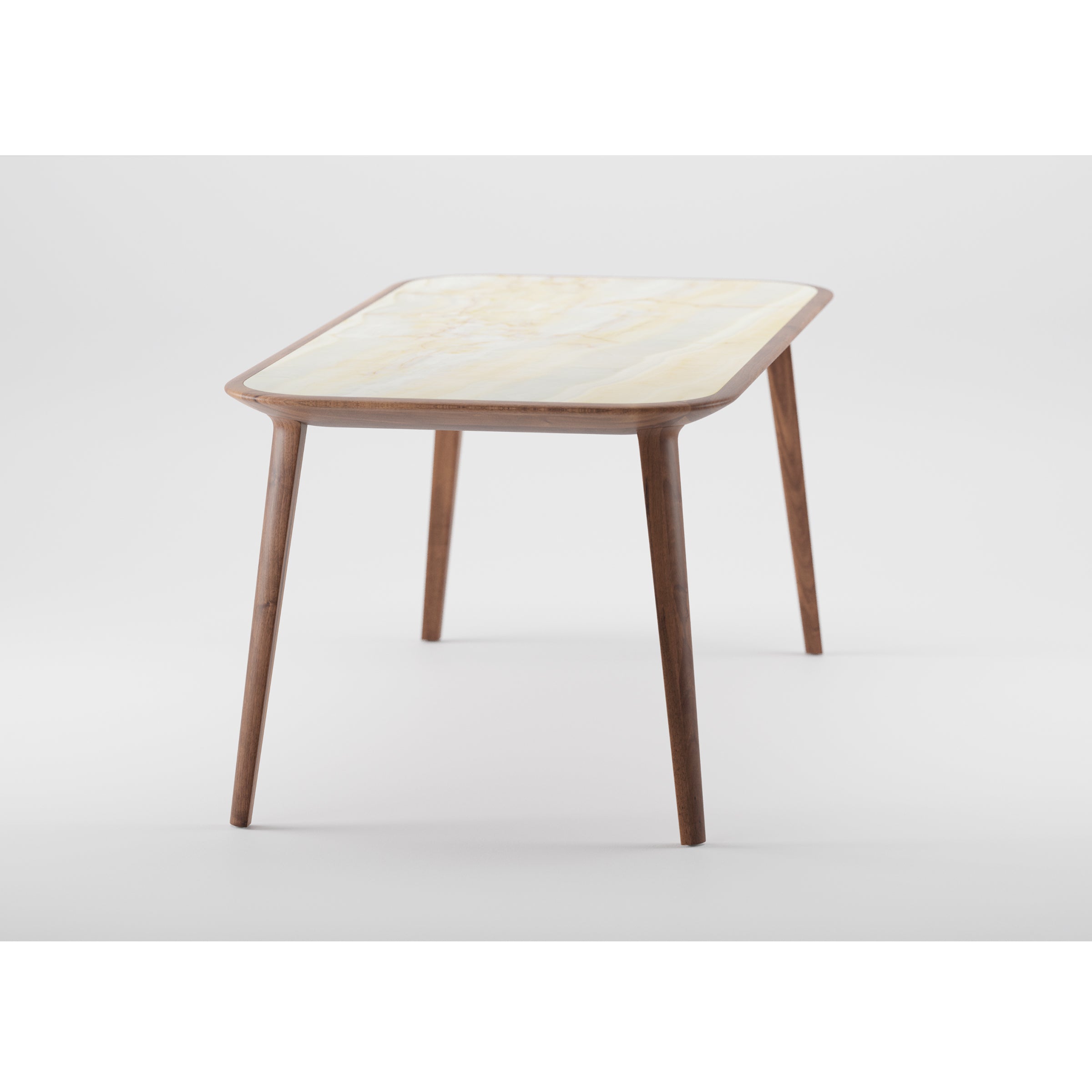 The Artisan KALOTA Table is a modern, minimalist side table made from solid wood with slim, tapered legs and a cream-colored rectangular top. Its sleek design is enhanced by a smooth natural oil finish and set against a plain white backdrop.