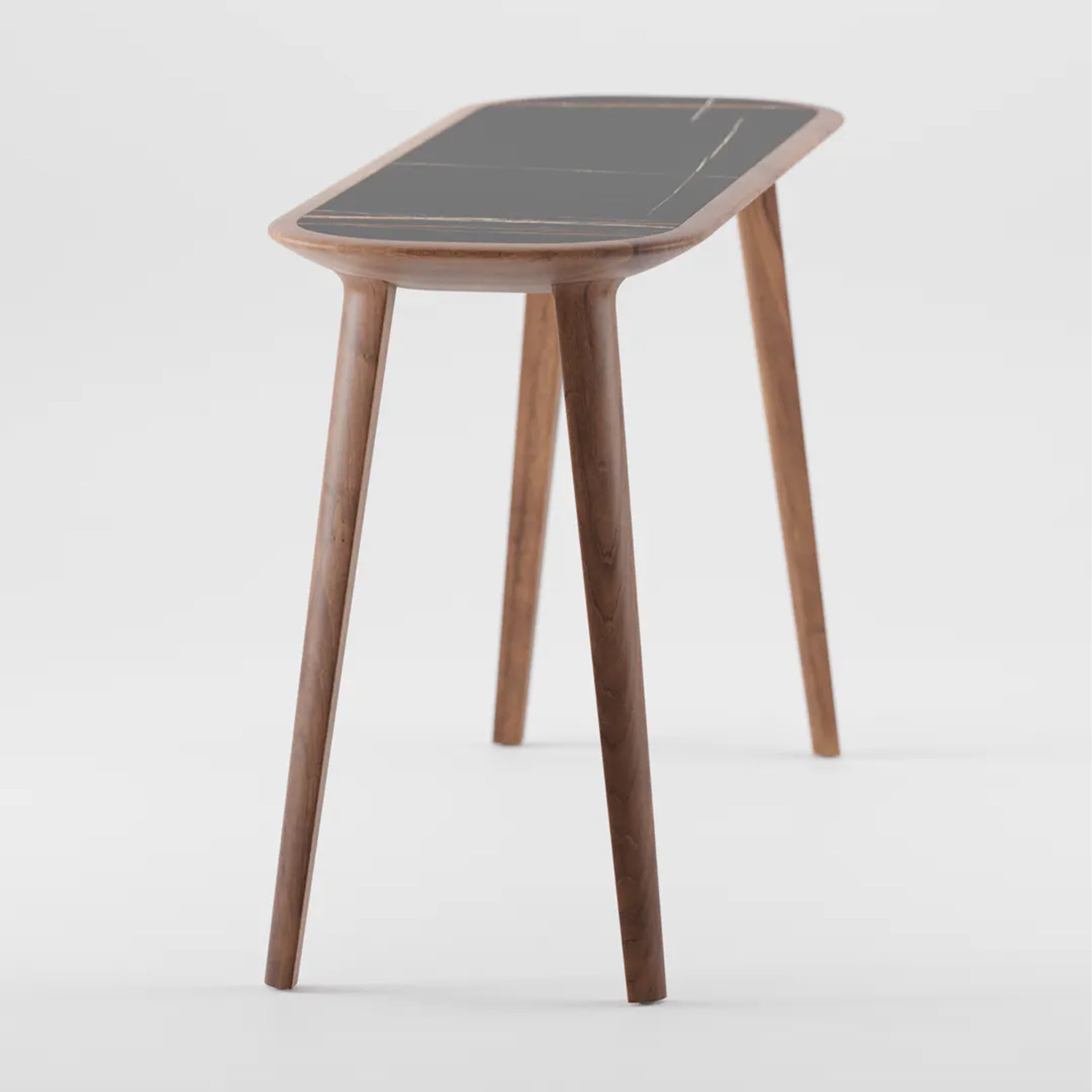 The Artisan KALOTA Console Table boasts a sleek wooden design with a rectangular black top featuring rounded edges and exquisite wood texture. Supported by four angled, tapered legs, its minimalist style combines environmentally-friendly materials with modern aesthetics.